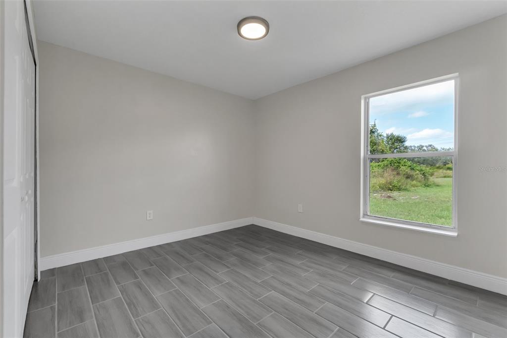 506 Peace Way Kissimmee, FL 34759 - Photo 27 of 34 an empty room with wooden floor and windows