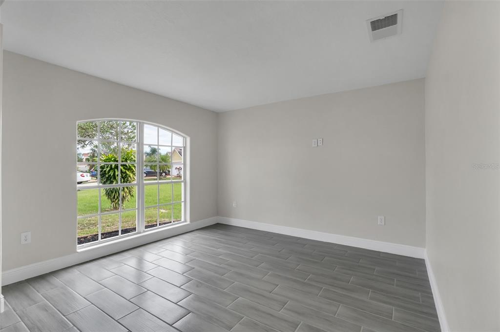 506 Peace Way Kissimmee, FL 34759 - Photo 31 of 34 an empty room with wooden floor and windows