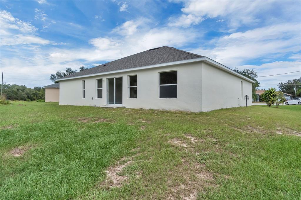 506 Peace Way Kissimmee, FL 34759 - Photo 33 of 34 a house that is sitting in the grass with large windows and trees
