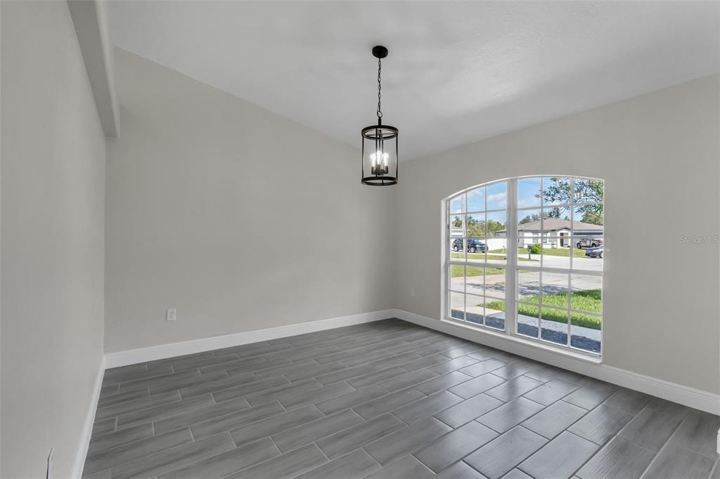 506 Peace Way Kissimmee, FL 34759 - Photo 5 of 34 wooden floor in an empty room with a window