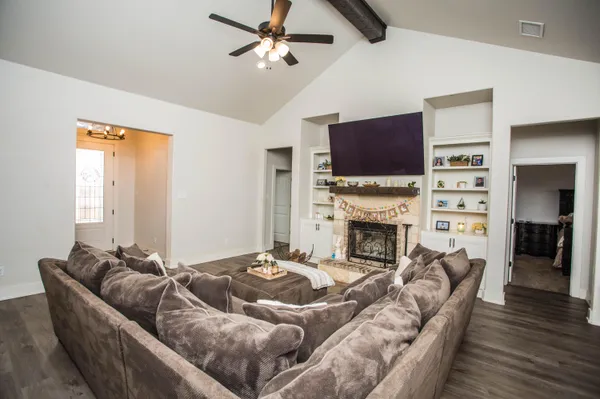 a living room with furniture a fireplace and a flat screen tv