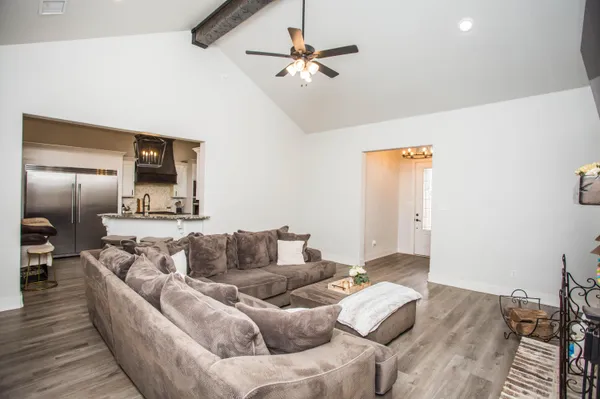 a kitchen with kitchen island granite countertop a table chairs refrigerator and microwave