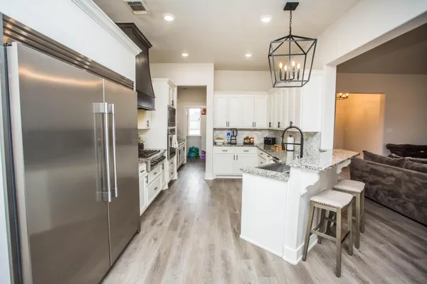 a kitchen with granite countertop a sink stainless steel appliances and cabinets