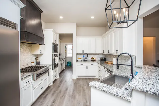 a kitchen with stainless steel appliances granite countertop a refrigerator and a stove