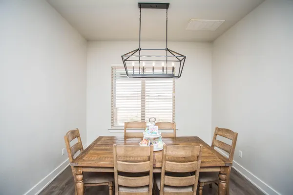 a dining room with wooden floor and chandelier
