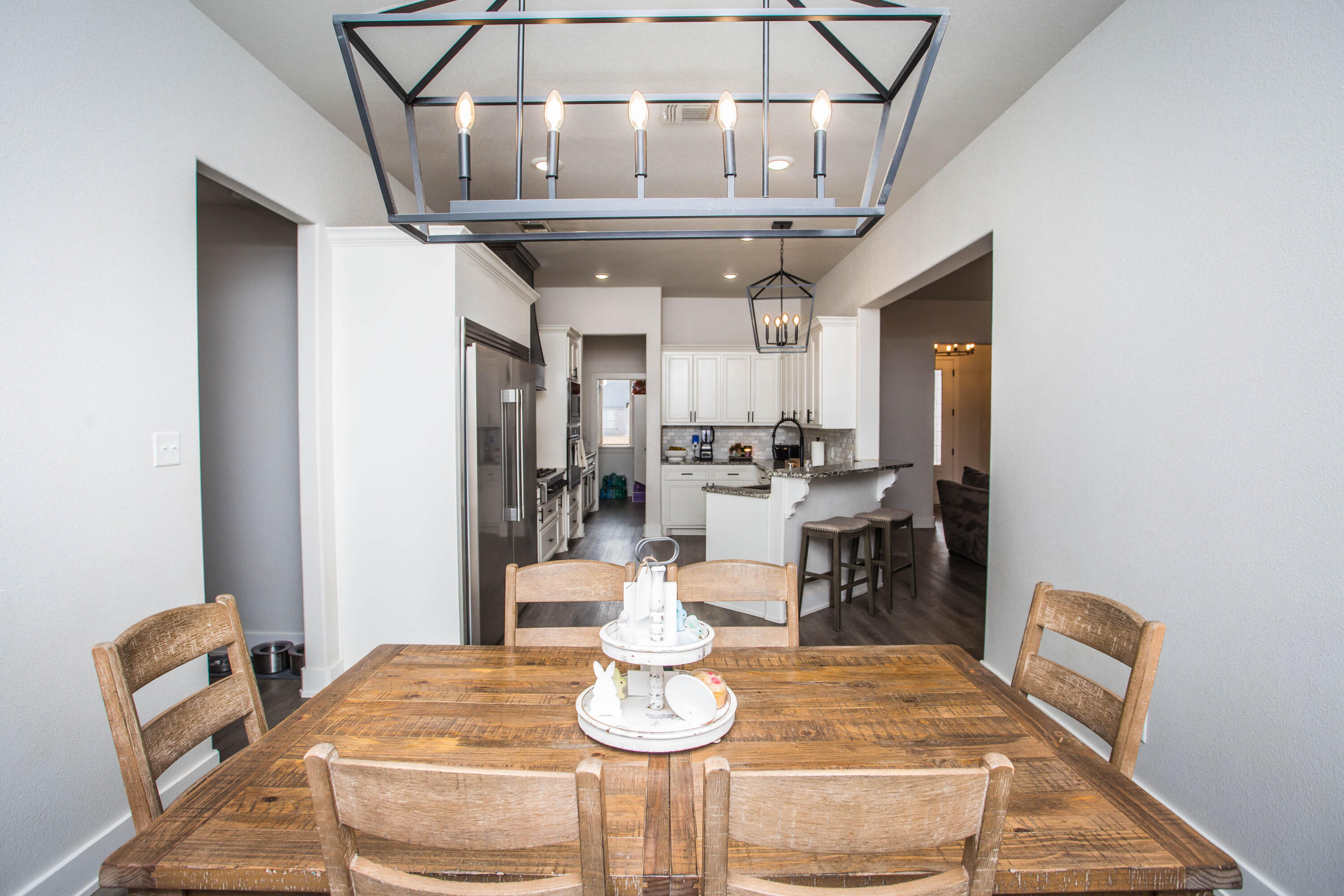 2204 County Road 7815 Lubbock, TX 79423 - Photo 24 of 58 a dining room with wooden floor and chandelier