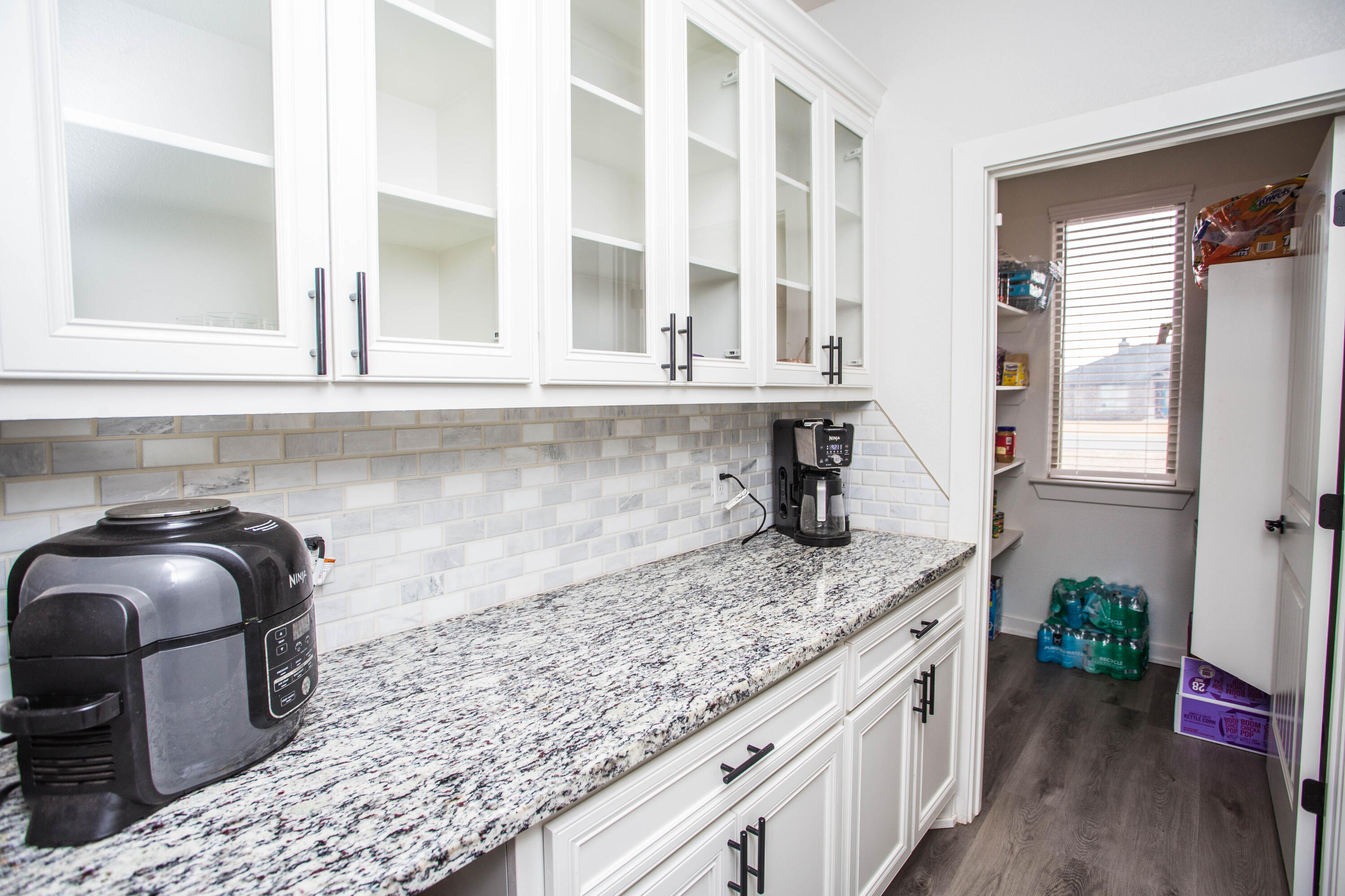 2204 County Road 7815 Lubbock, TX 79423 - Photo 25 of 58 a kitchen with granite countertop lots of counter top space and wooden floor