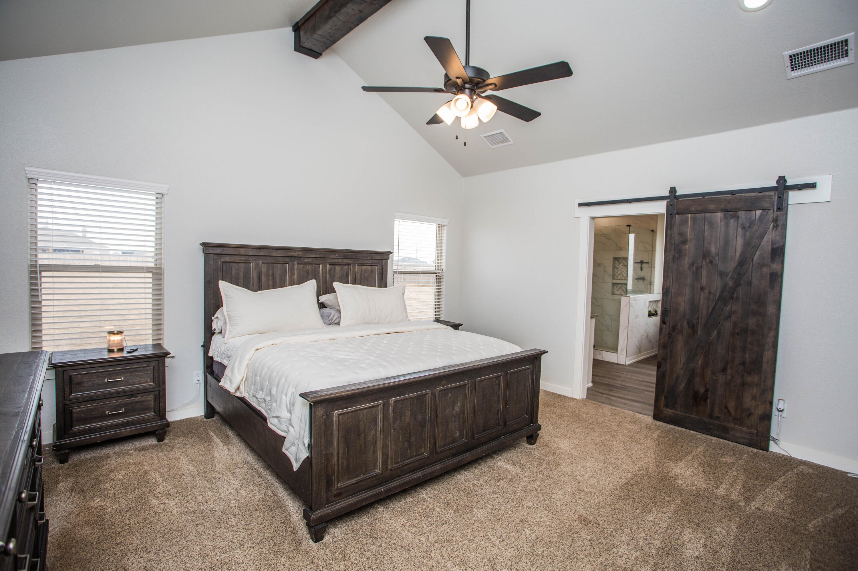 2204 County Road 7815 Lubbock, TX 79423 - Photo 29 of 58 a bedroom with a bed and a chandelier