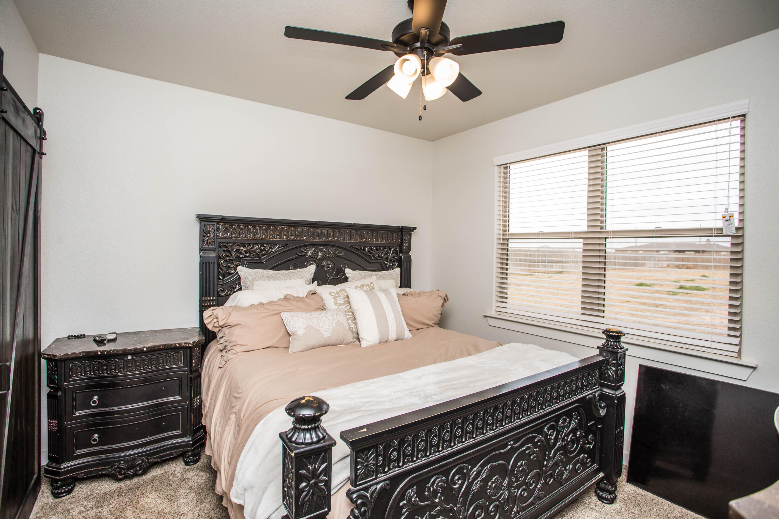 2204 County Road 7815 Lubbock, TX 79423 - Photo 40 of 58 a bedroom with a bed and a chandelier