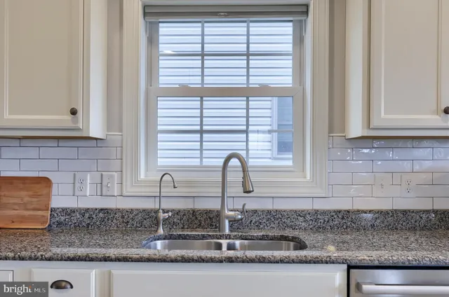 a kitchen with granite countertop a sink and a window
