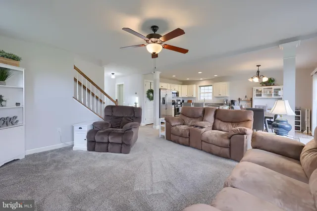 a living room with furniture and a ceiling fan