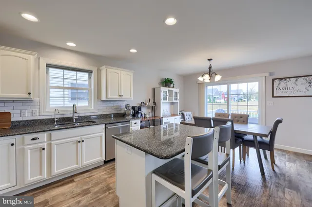 a large kitchen with granite countertop lots of counter space and windows