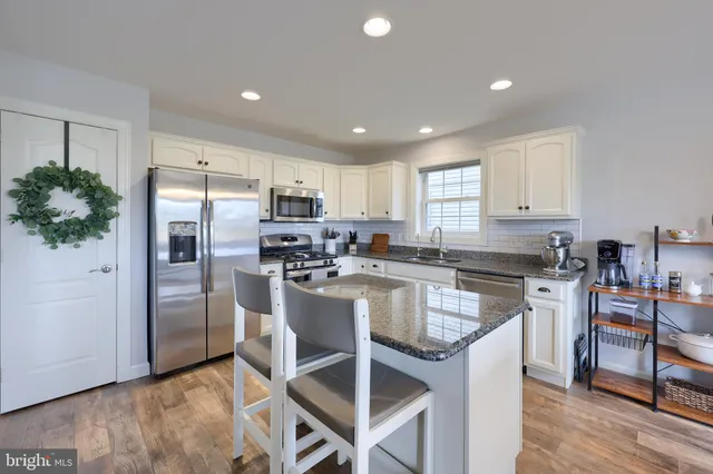a kitchen with granite countertop a center island stainless steel appliances and cabinets