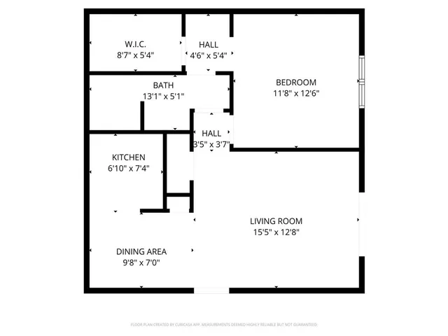 an empty room with wooden floor and windows with curtains