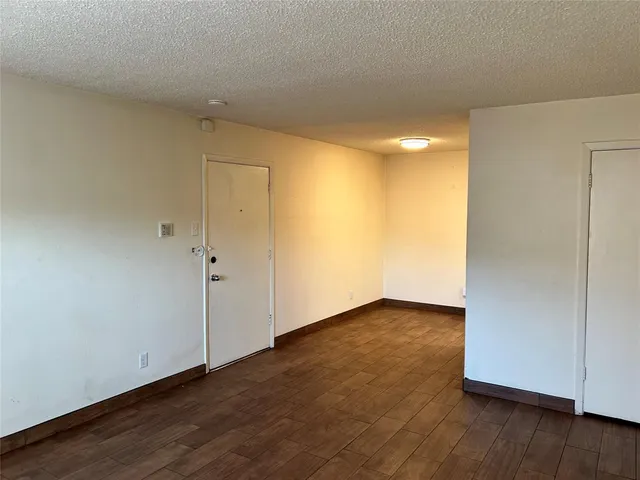 an empty room with wooden floor and sliding door