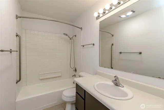 a bathroom with a toilet a sink a mirror a bathtub and shower