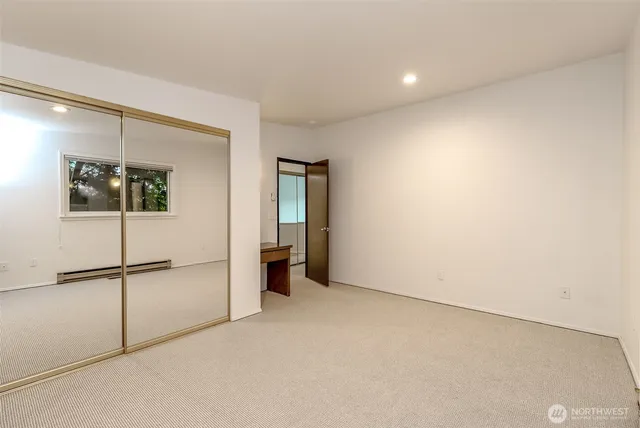 an empty room with a refrigerator and mirror