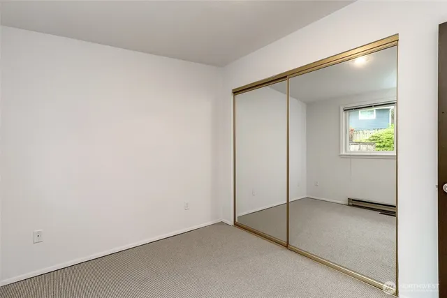 an empty room with windows and closet