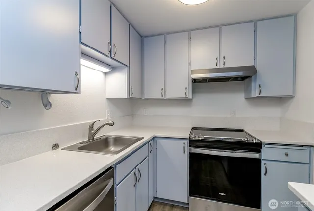 a kitchen with cabinets appliances a sink and a stove