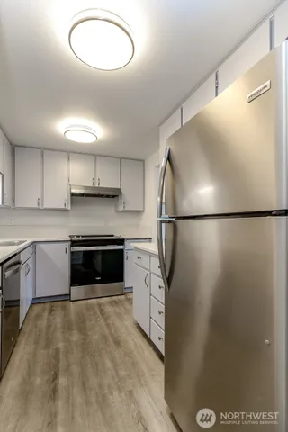 a kitchen with stainless steel appliances granite countertop a refrigerator a sink and a stove