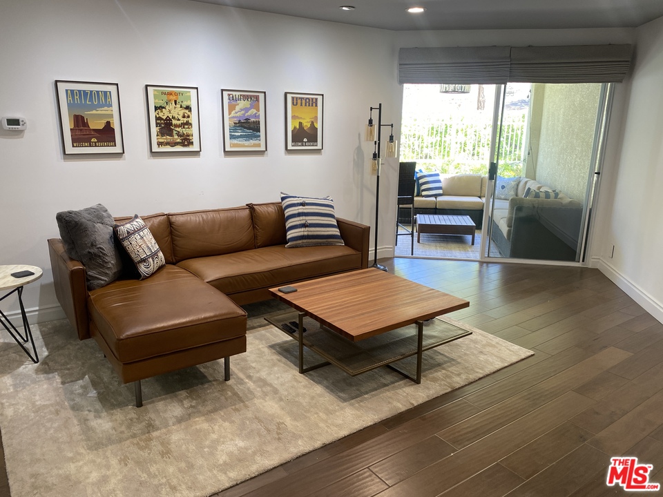 5805 Oak Bend Lane, Unit 210 Oak Park, CA 91377 - Photo 2 of 20 a living room with furniture a rug and a large window