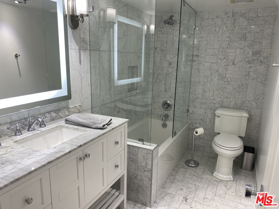 5805 Oak Bend Lane, Unit 210 Oak Park, CA 91377 - Photo 11 of 20 a bathroom with a granite countertop sink a toilet and shower