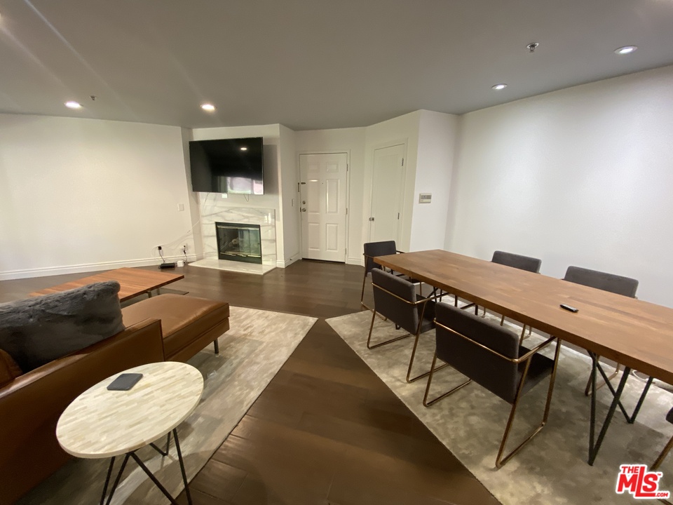 5805 Oak Bend Lane, Unit 210 Oak Park, CA 91377 - Photo 4 of 20 a living room with a table chairs and a fireplace
