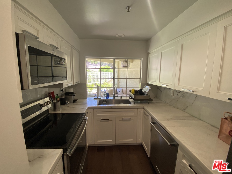 5805 Oak Bend Lane, Unit 210 Oak Park, CA 91377 - Photo 9 of 20 a kitchen with a sink stove top oven and cabinets