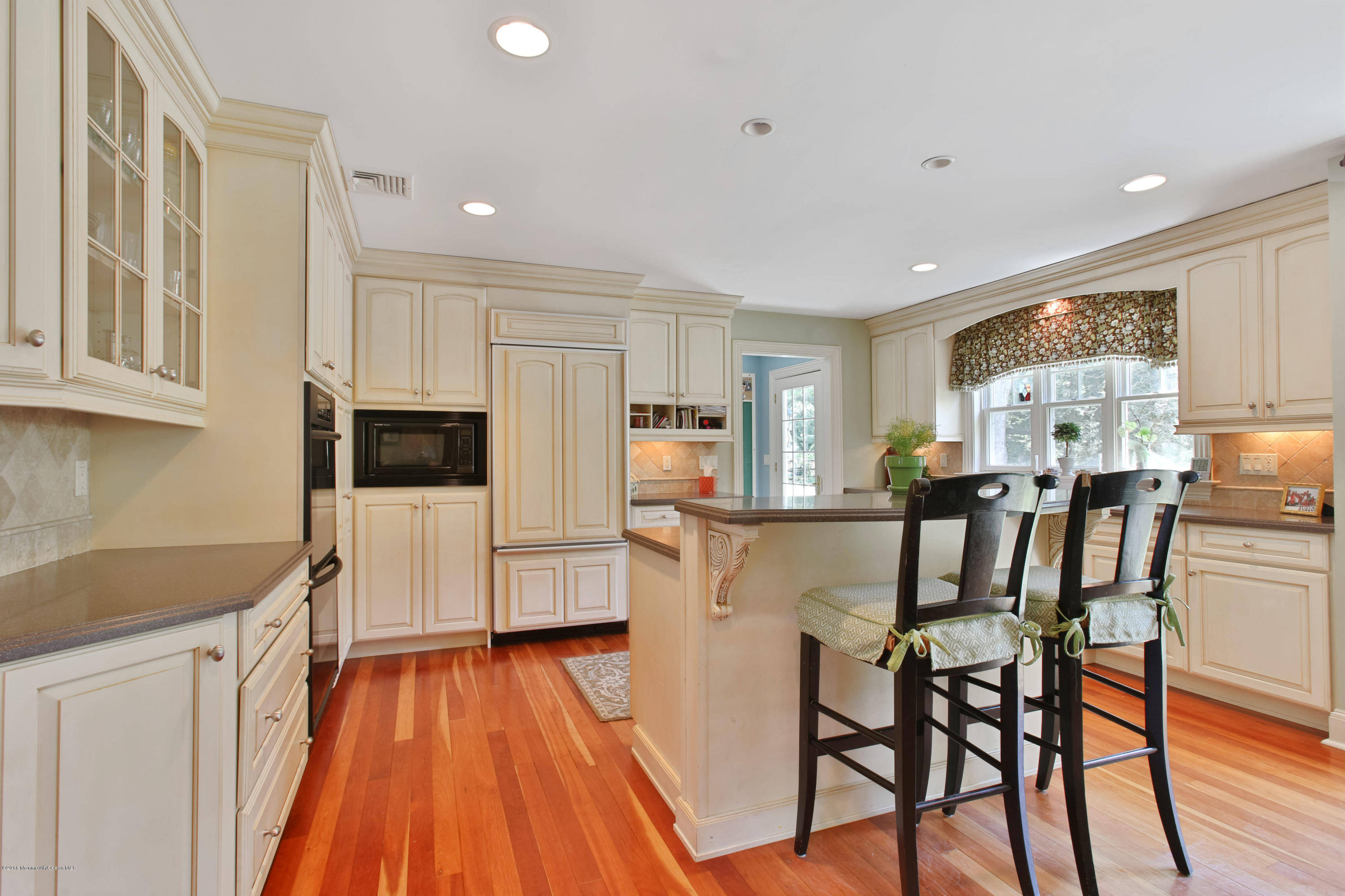 7 Partridge Way Colts Neck, NJ 07722 - Photo 16 of 50 a kitchen with stainless steel appliances granite countertop a refrigerator oven a sink dishwasher and white cabinets with wooden floor