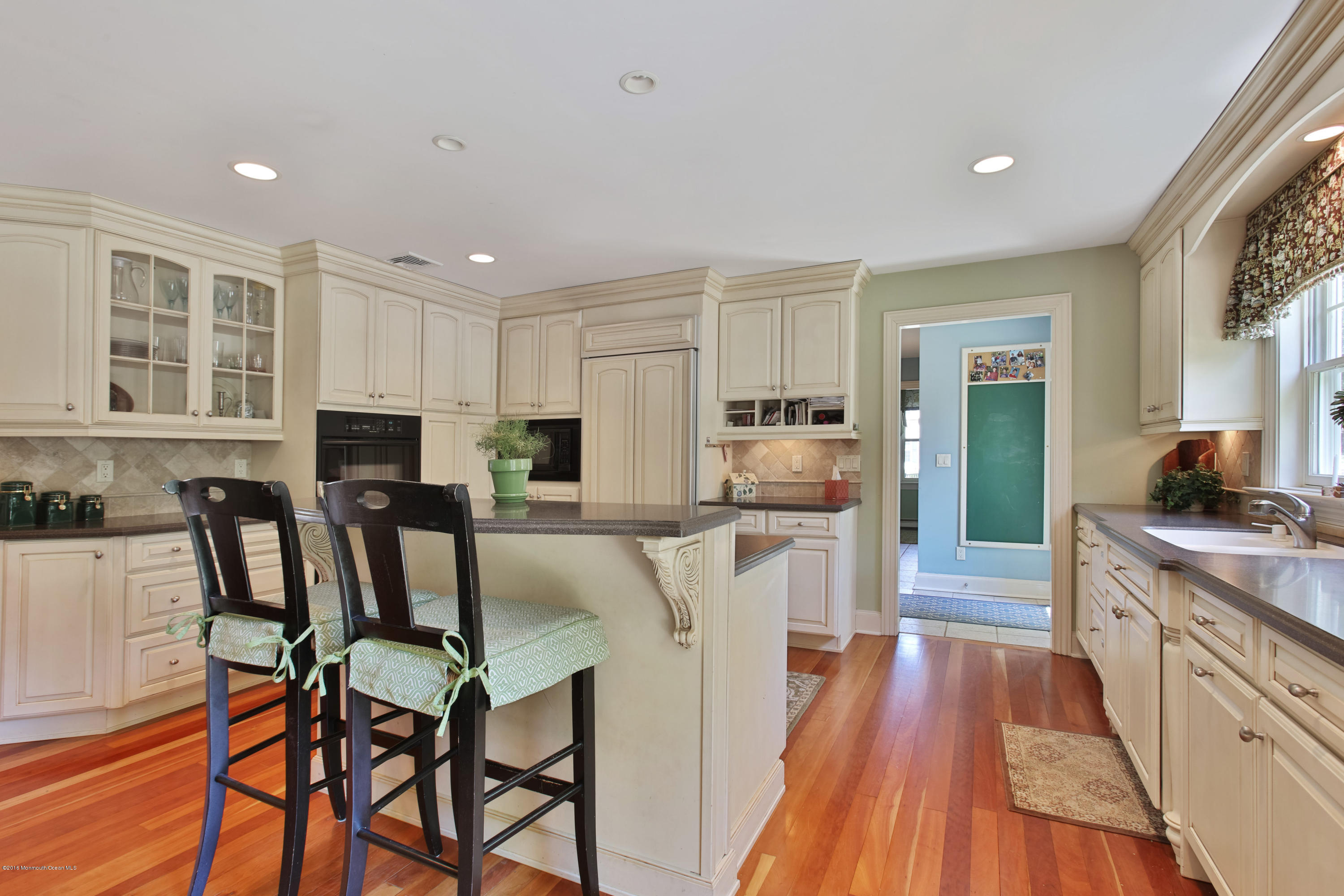 7 Partridge Way Colts Neck, NJ 07722 - Photo 17 of 50 a kitchen with stainless steel appliances kitchen island granite countertop a table chairs refrigerator and sink