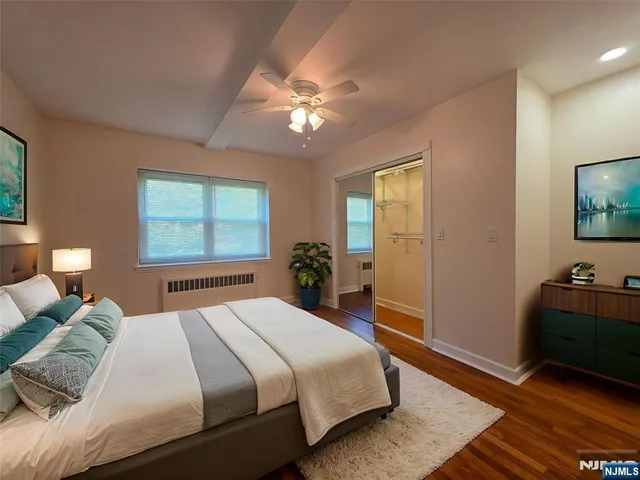 a bedroom with a bed and a flat tv screen on dresser