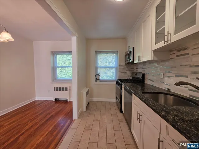 a kitchen with granite countertop a sink stove and cabinets
