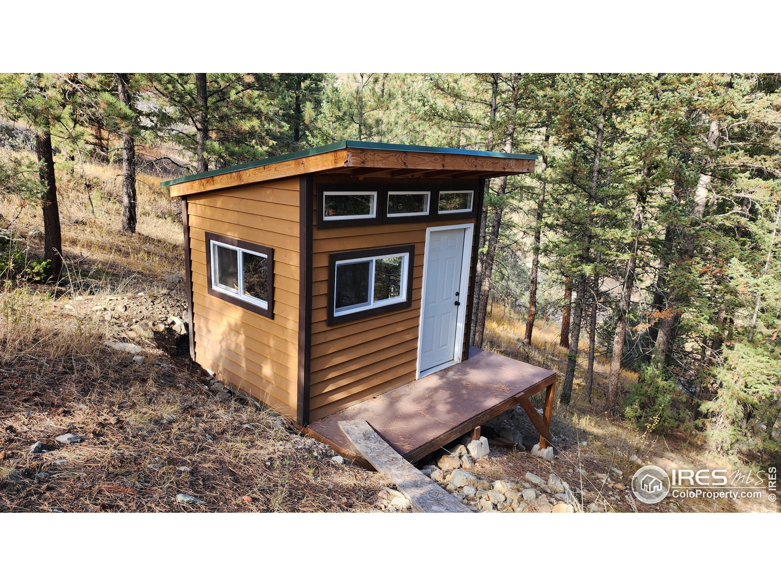 84 Copper Hill Road Drake, CO 80515 - Photo 14 of 28 a view of a backyard with barn and wooden fence