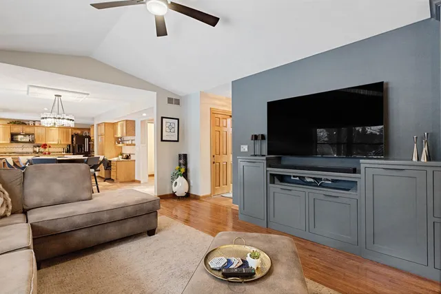 a living room with stainless steel appliances furniture a fireplace and a window