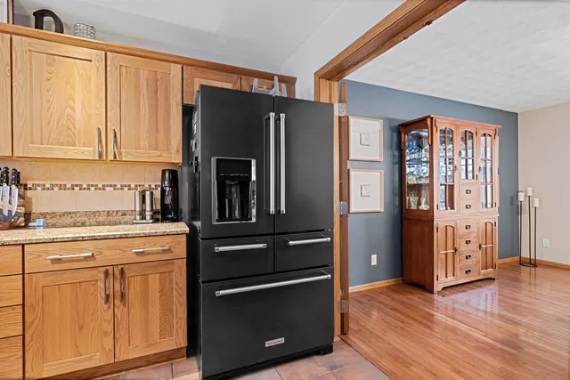 a kitchen with stainless steel appliances kitchen island granite countertop a refrigerator and a sink