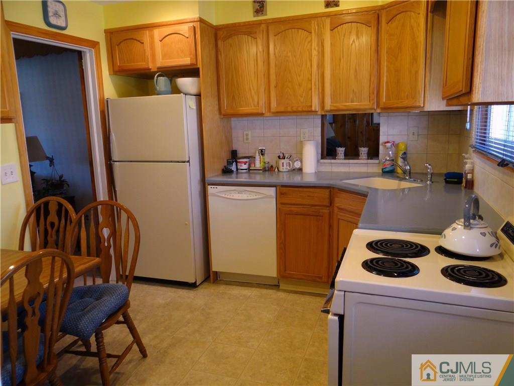 2 Roger Road Edison, NJ 08817 - Photo 6 of 16 a kitchen with a refrigerator a stove a sink and cabinets
