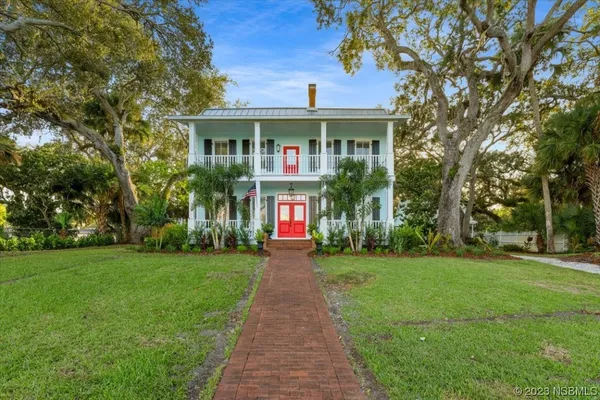 a front view of a house with a yard and trees