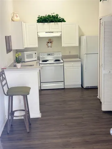 a kitchen with a table chairs stove and cabinets