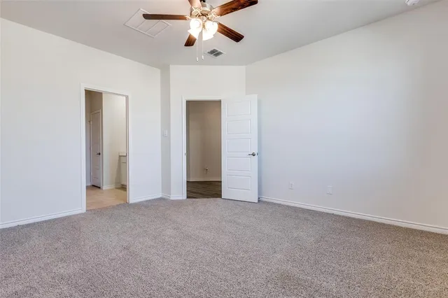 an empty room with chandelier fan