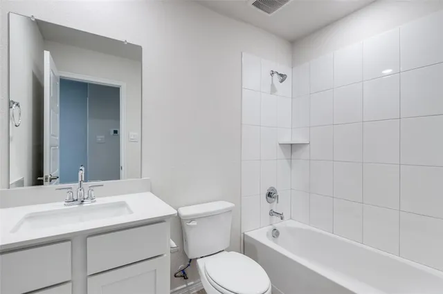 a bathroom with a sink toilet vanity and shower