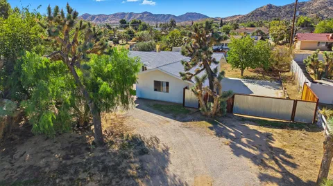 a view of a house with a backyard and a tree