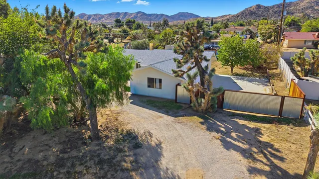 a view of a house with a backyard and a tree