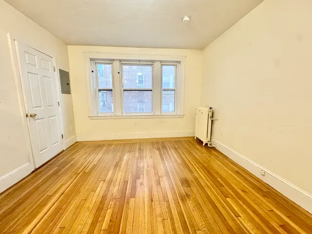 a view of a room with wooden floor and windows