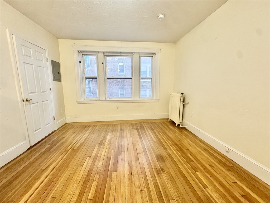 1615 Commonwealth Avenue, Unit 11 Boston, MA 02135 - Photo 3 of 9 a view of a room with wooden floor and windows