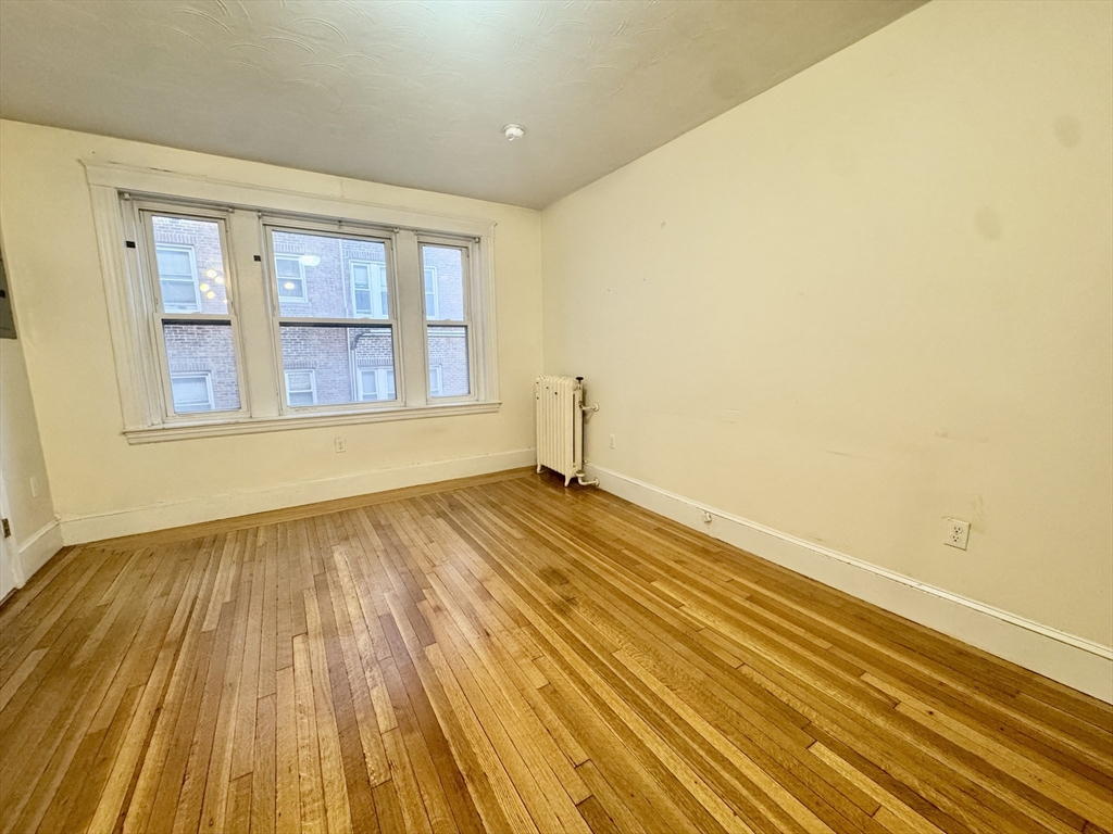 1615 Commonwealth Avenue, Unit 11 Boston, MA 02135 - Photo 4 of 9 a view of empty room with wooden floor and fan