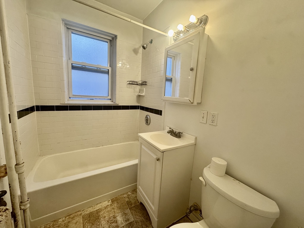 1615 Commonwealth Avenue, Unit 11 Boston, MA 02135 - Photo 7 of 9 a bathroom with a sink a toilet and shower