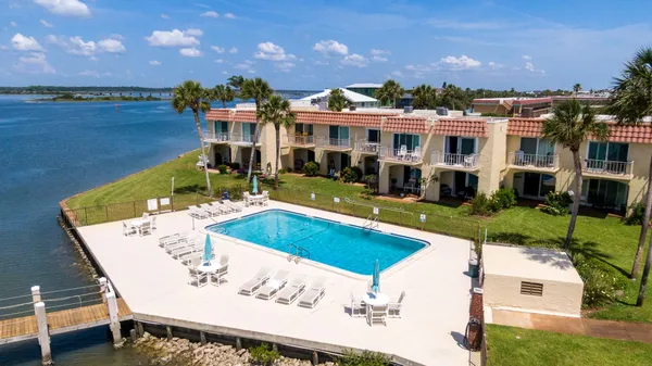 a view of a house with pool and chairs