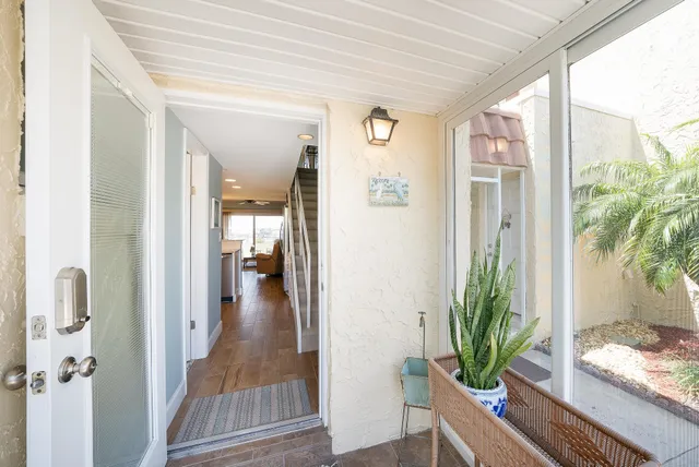 a view of a hallway view with wooden floor and a potted plant