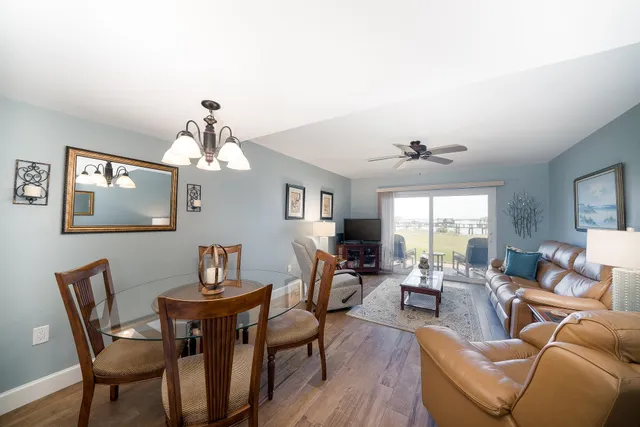 a view of a dining room with furniture a chandelier and wooden floor