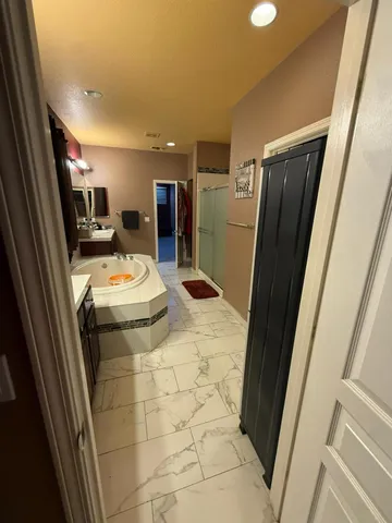 a spacious bedroom with a bed and a chandelier